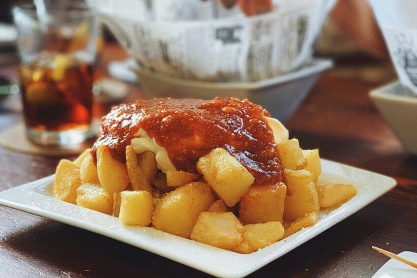 Un plato de papas fritas con kétchup y una bebida al fondo. 5