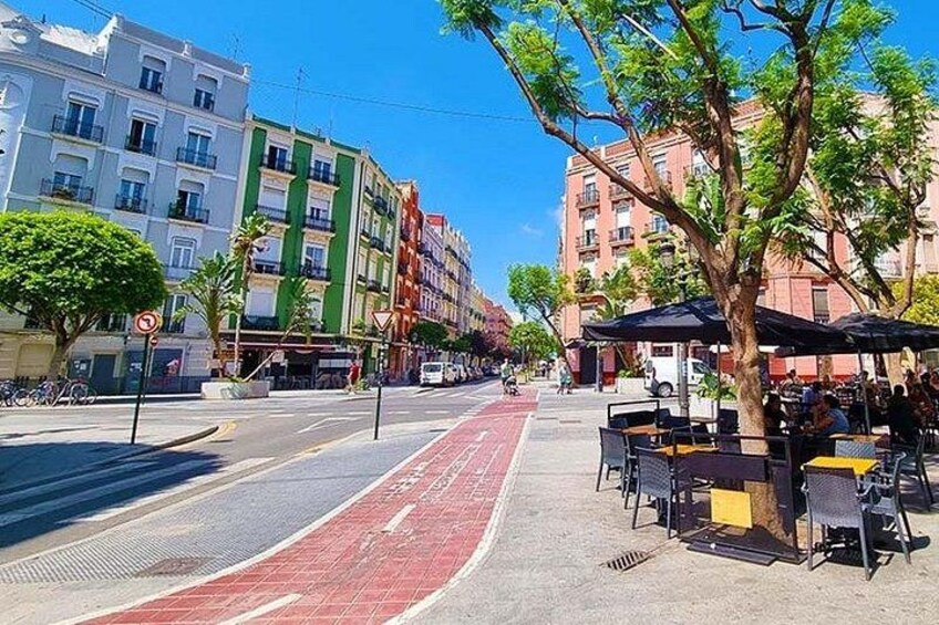 Una calle con carril bici rojo, árboles y edificios. 4