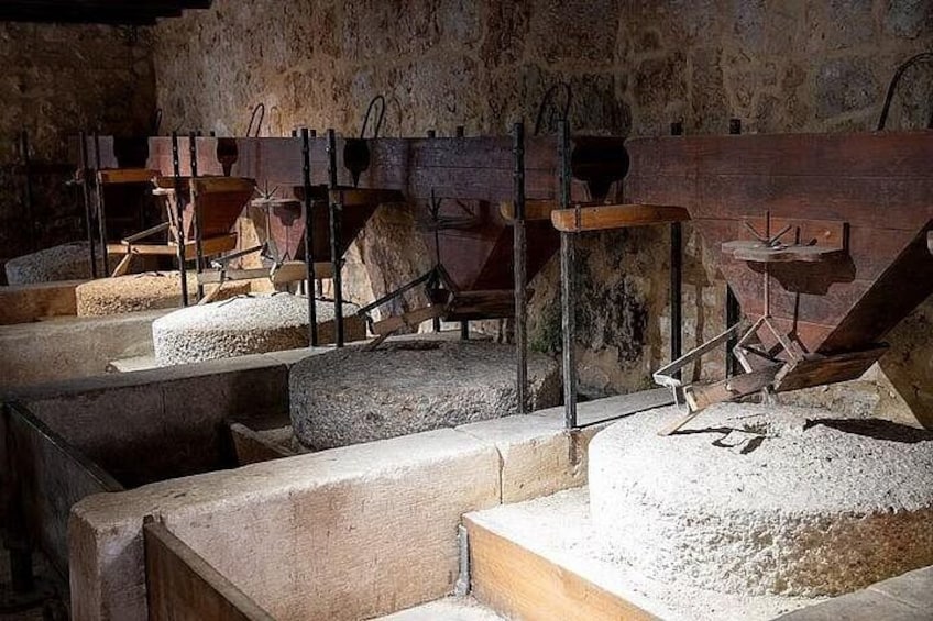 Un molino histórico con canales de piedra y mecanismos de madera. 2