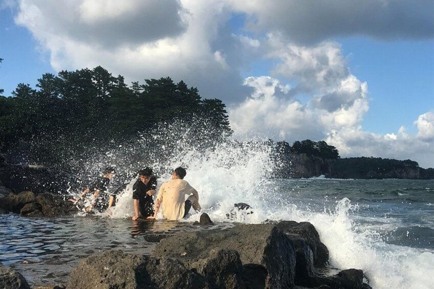 People playing in the water near rocks and cliffs. 5