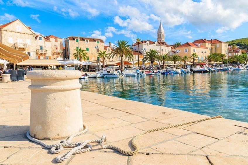 A waterfront promenade with boats, a stone bollard, and historic buildings. 4