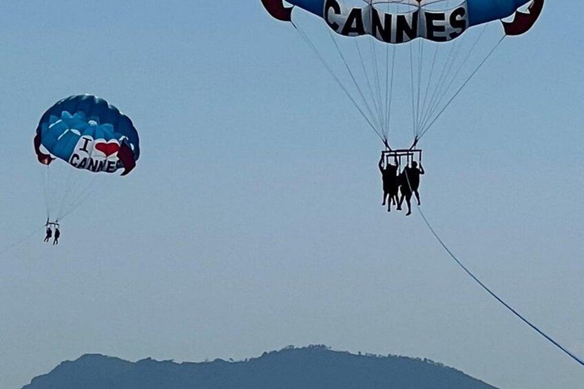 Two parachutes with people attached, one with 'I love Cannes' and the other with 'Cannes' written on it. 3