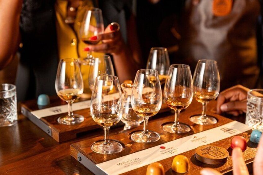 A tasting event with multiple wine glasses on wooden stands. 2