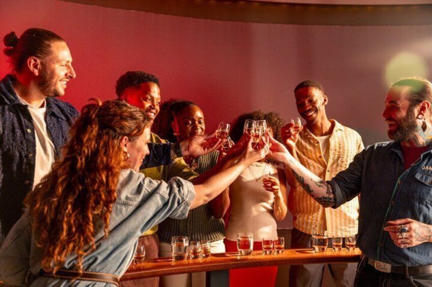 A group of people toasting with drinks at a bar. 4