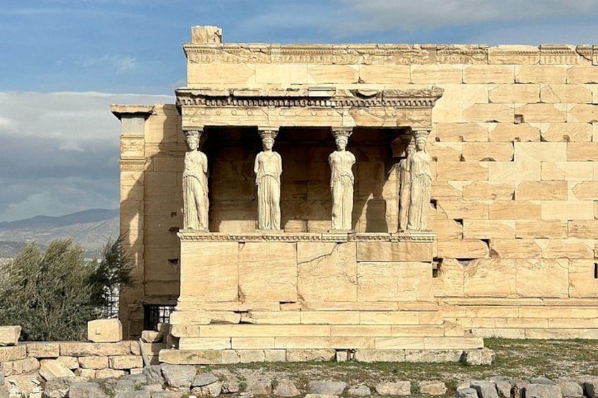 A stone structure with columns and a frieze, likely part of an ancient Greek temple. 1