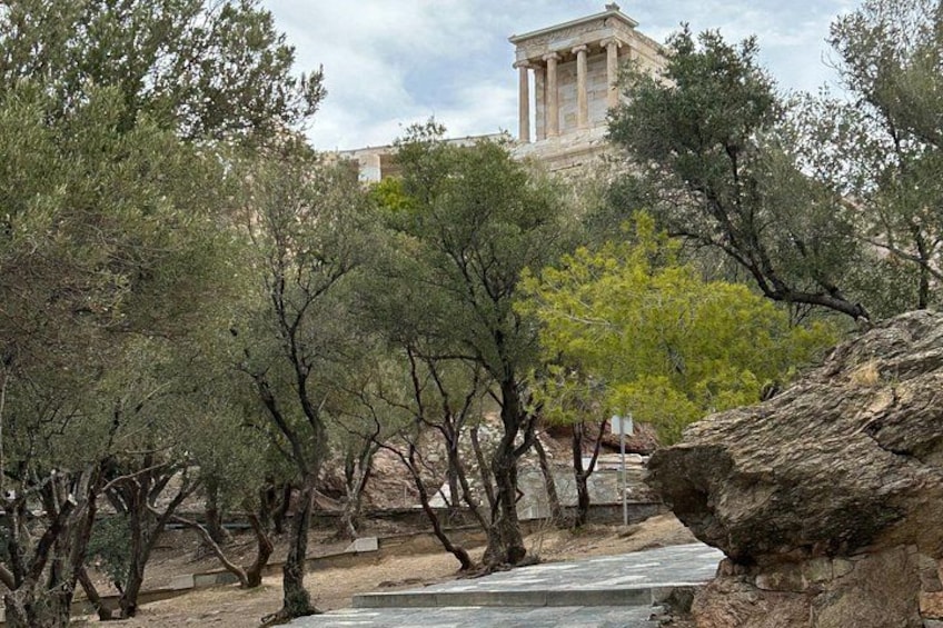Paesaggio roccioso con alberi e un edificio classico sullo sfondo. 2