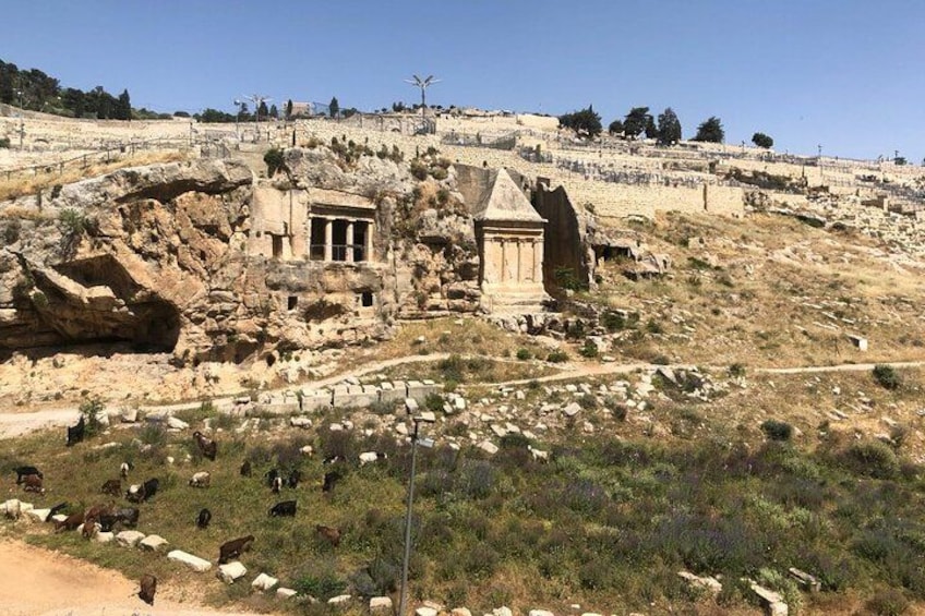 Ancient ruins with a temple and a tomb on a hillside. 2