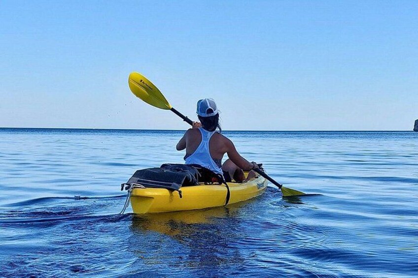 A person kayaking on calm water. 3