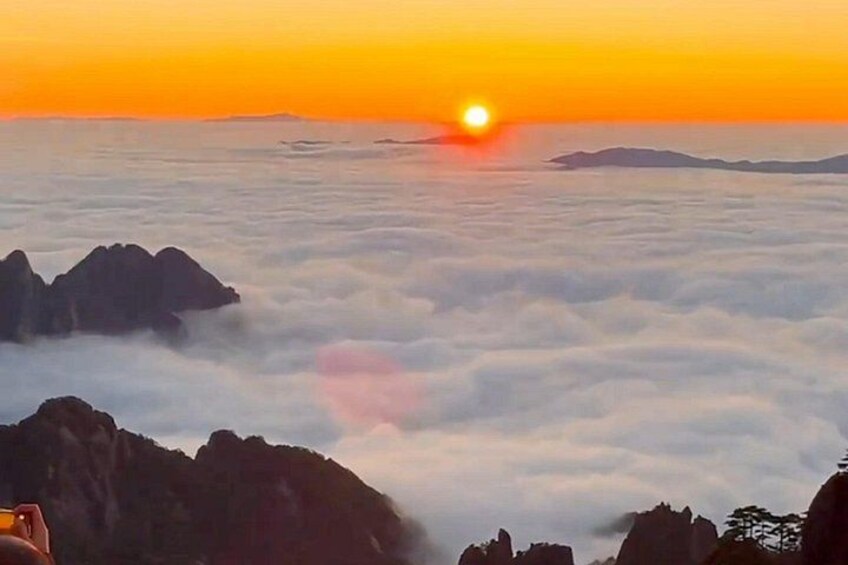 A sunrise over a cloud-covered landscape with rocky outcrops. 4