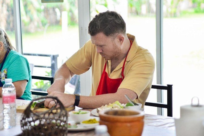 A person preparing food at a table with various ingredients and utensils. 4