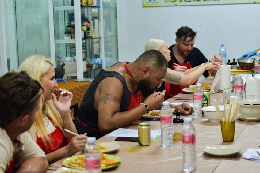 People dining at a table with various food items and drinks. 2