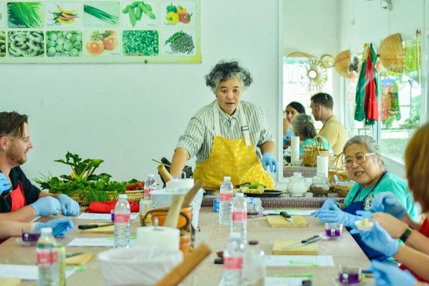A group of people engaged in a workshop with various tools and materials on a table. 2