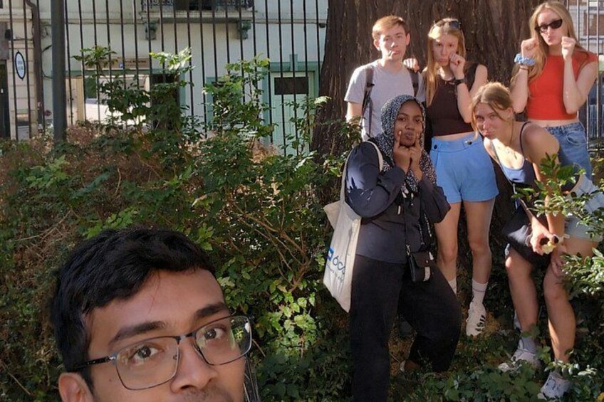 Un groupe de personnes se tient à l’extérieur, avec de la verdure et une clôture en arrière-plan. 5