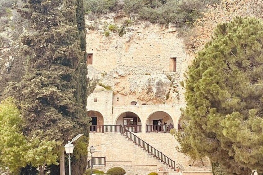 A stone building with arched doorways and a staircase leading up to it. 5