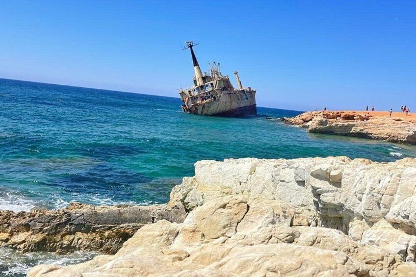 A shipwreck on a rocky coastline with clear blue water. 2