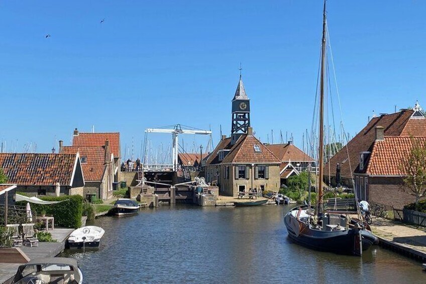 A harbor with boats, a clock tower, and traditional buildings. 1