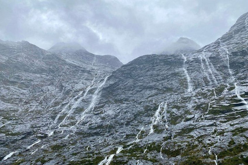 A mountainous landscape with a waterfall cascading down the slopes. 4
