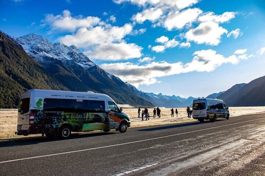 A bus on a road with mountains in the background. 5