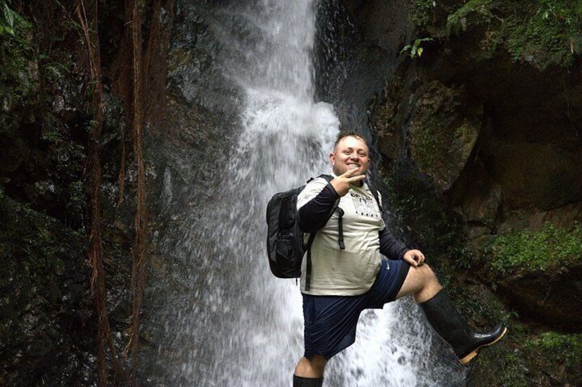 Une personne se tient sur un rocher, avec une cascade en arrière-plan. 4
