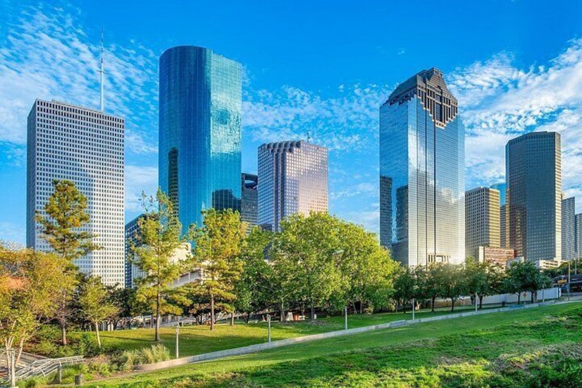 A cityscape with modern skyscrapers and a park with trees. 4