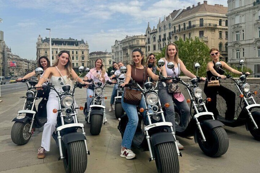 A group of people riding electric scooters on a city street. 5