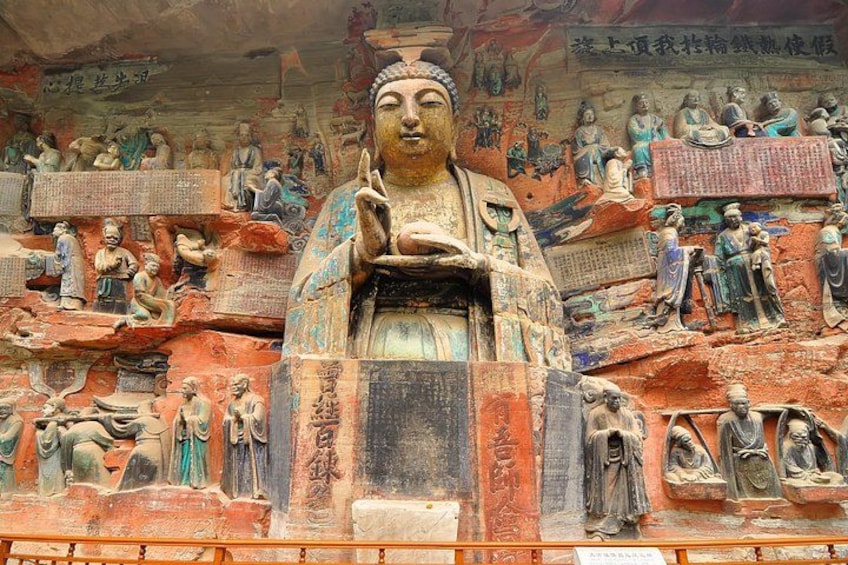 A large Buddha statue surrounded by smaller statues and carvings. 1
