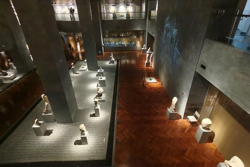 A spacious interior with high ceilings, large pillars, and a central walkway. 4