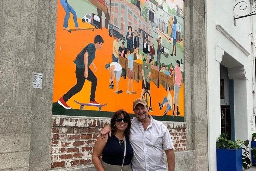 A mural on a brick wall with people engaged in various activities. 4