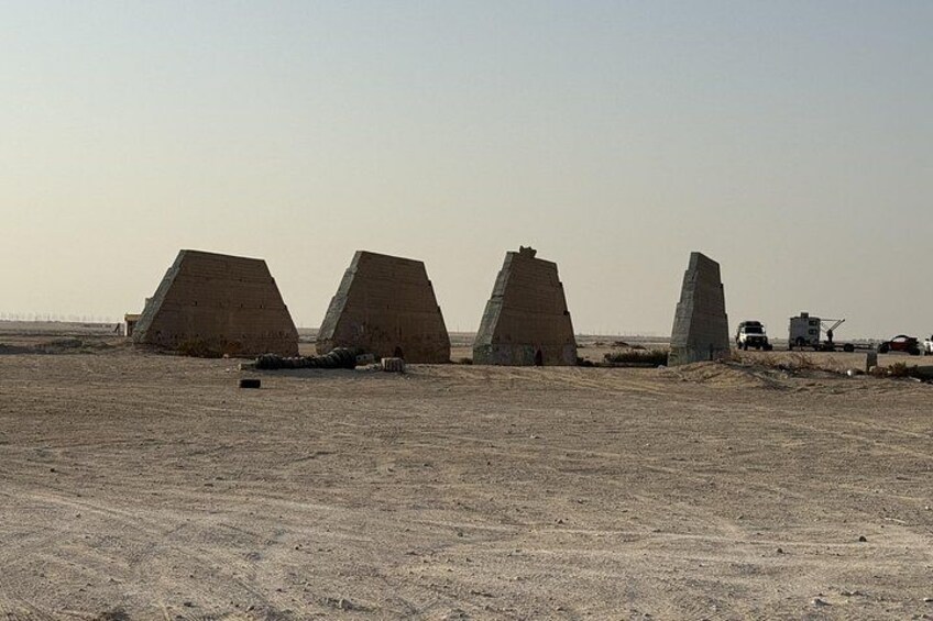 Three large stone structures in a desert landscape with a clear sky. 3
