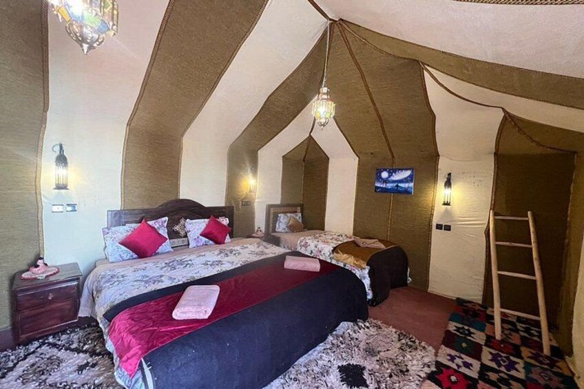Un dormitorio con tienda de campaña, una cama, almohadas, un televisor y una escalera. 5