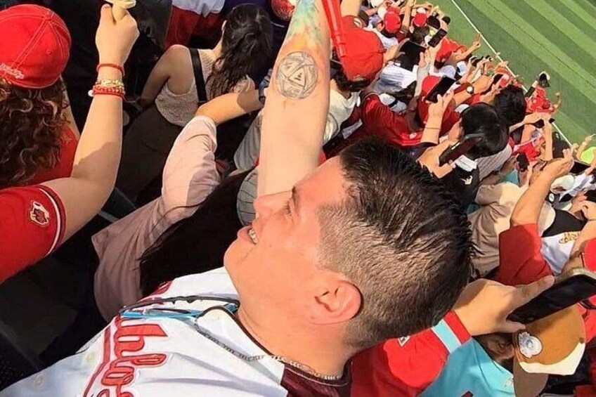 Una multitud de personas con camisetas deportivas rojas y blancas, algunas con las manos levantadas. 5