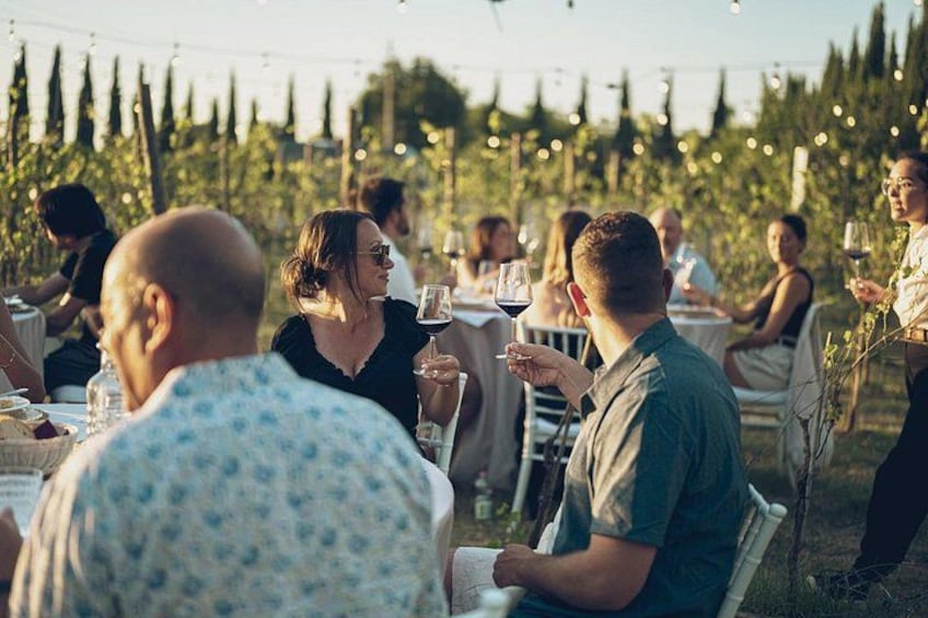 Mensen dineren buiten bij een tuinfestival met lichtslingers. 1
