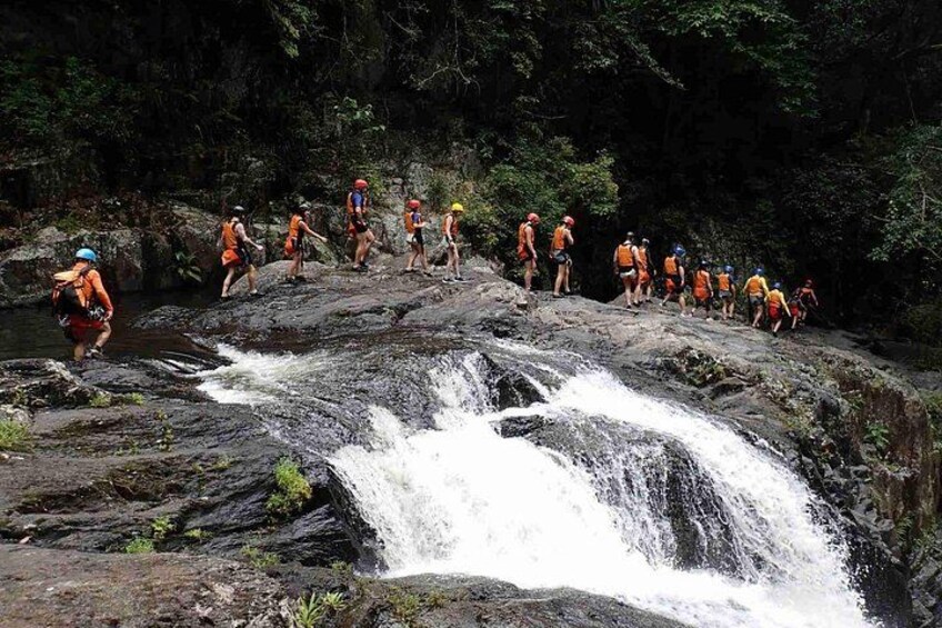 A group of hikers on a rocky waterfall trail. 4