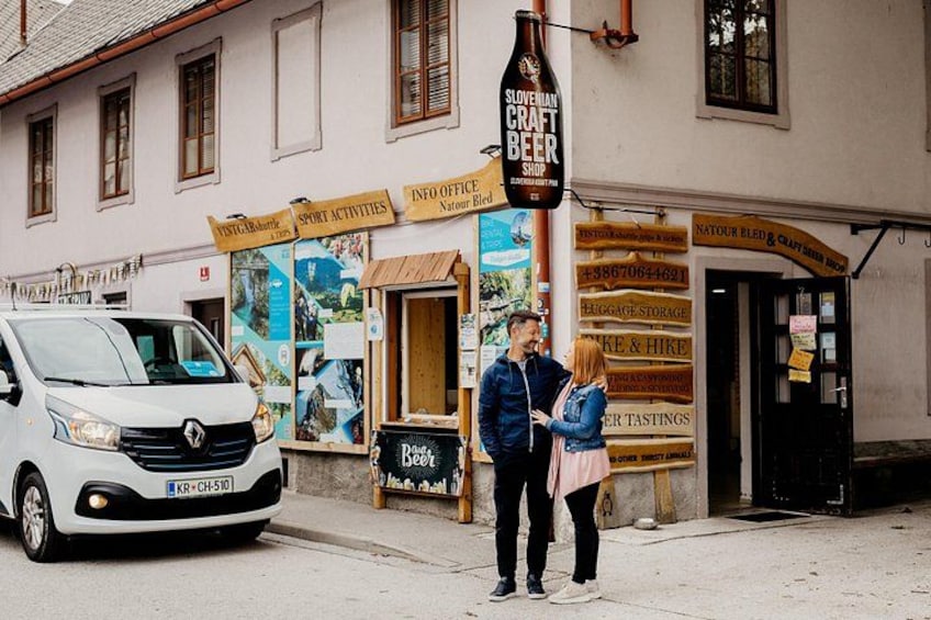 A white van parked in front of a building with a sign for Slovenian Craft Beer Shop. 3