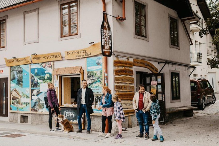 A building with signs for Slivovka Craft Beer, sport activities, and an info office. 1