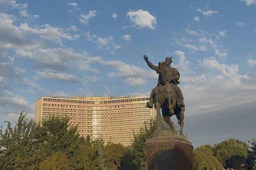 A statue of a person on horseback in front of a large building. 2
