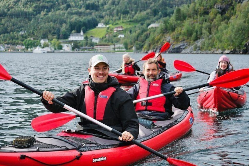 Personas haciendo kayak en un lago con kayaks y remos rojos. 2