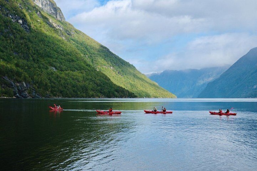 Kayakistas en un lago tranquilo con montañas al fondo. 3