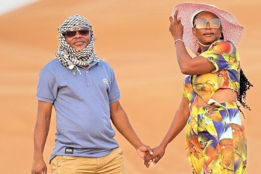 Two people holding hands in a desert landscape. 2