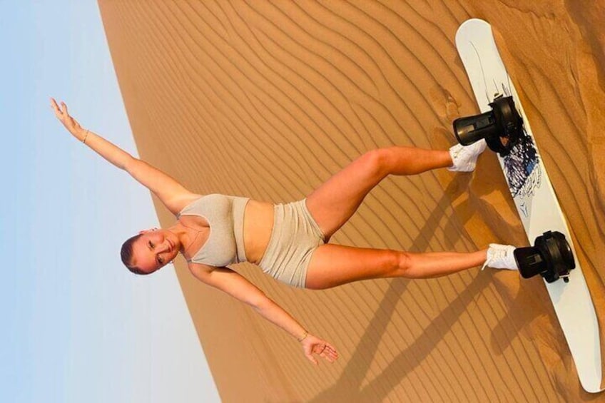 A person snowboarding on a sandy surface. 4