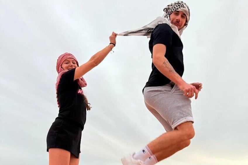 Two people jumping in the air, holding hands. 5