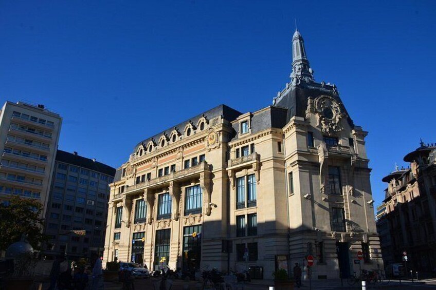 A historic building with a clock tower, large windows, and ornate architectural details. 2