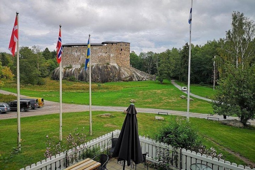 A grassy area with a stone wall and flags. 3