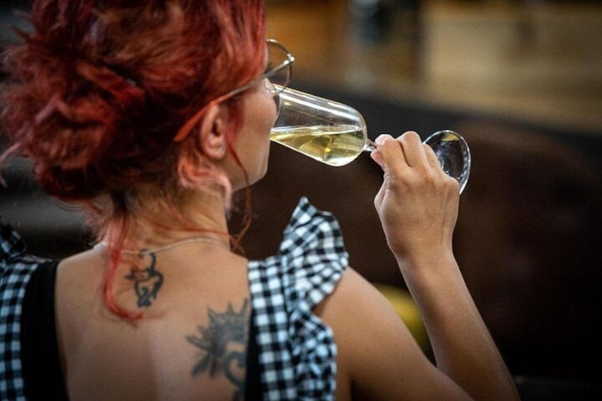 A person with red hair drinking from a glass. 5