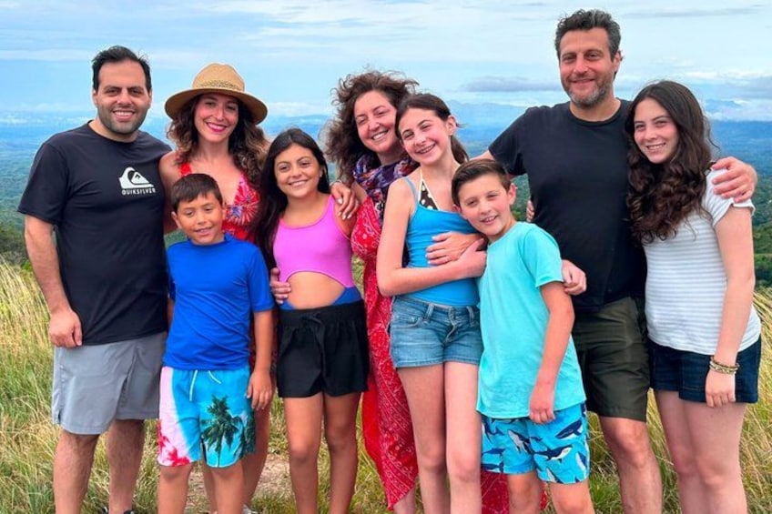 A group of people standing outdoors with a mountainous landscape in the background. 4