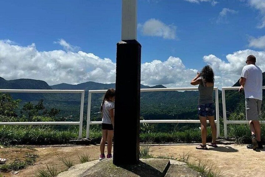A group of people standing on a viewing platform overlooking a mountainous landscape. 2