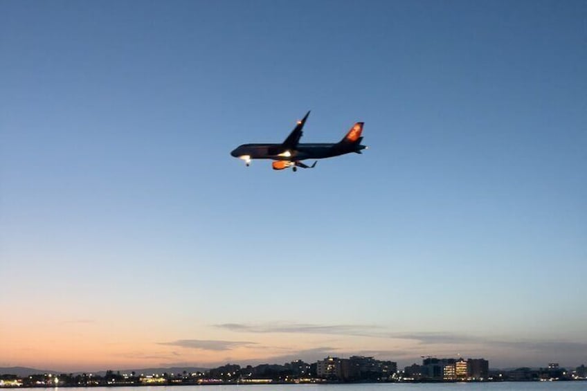 An airplane flying over a city skyline at dusk. 2