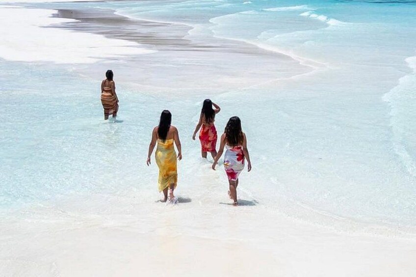 Ein Strand mit klarem Wasser und Spaziergängern. 5