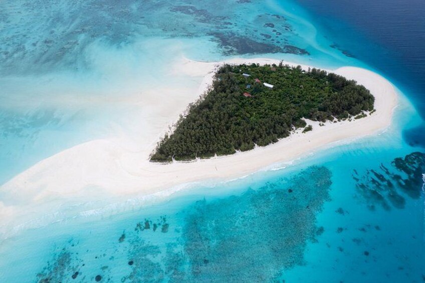 Eine Vogelperspektive einer kleinen Insel mit einem weißen Sandstrand und dichtem, grünen Wald. 4