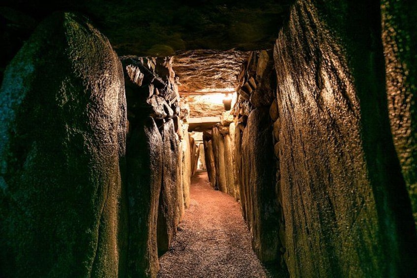 Un túnel estrecho y tenuemente iluminado, con paredes rugosas y una viga de madera en el techo. 2